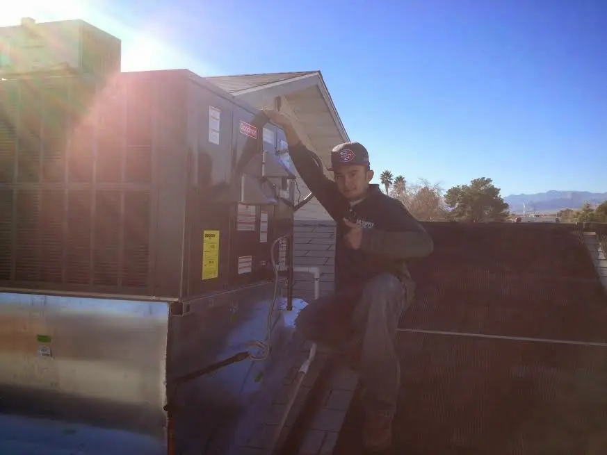 HVAC technician performing Heat Pump Repair on a rooftop unit in Radcliff